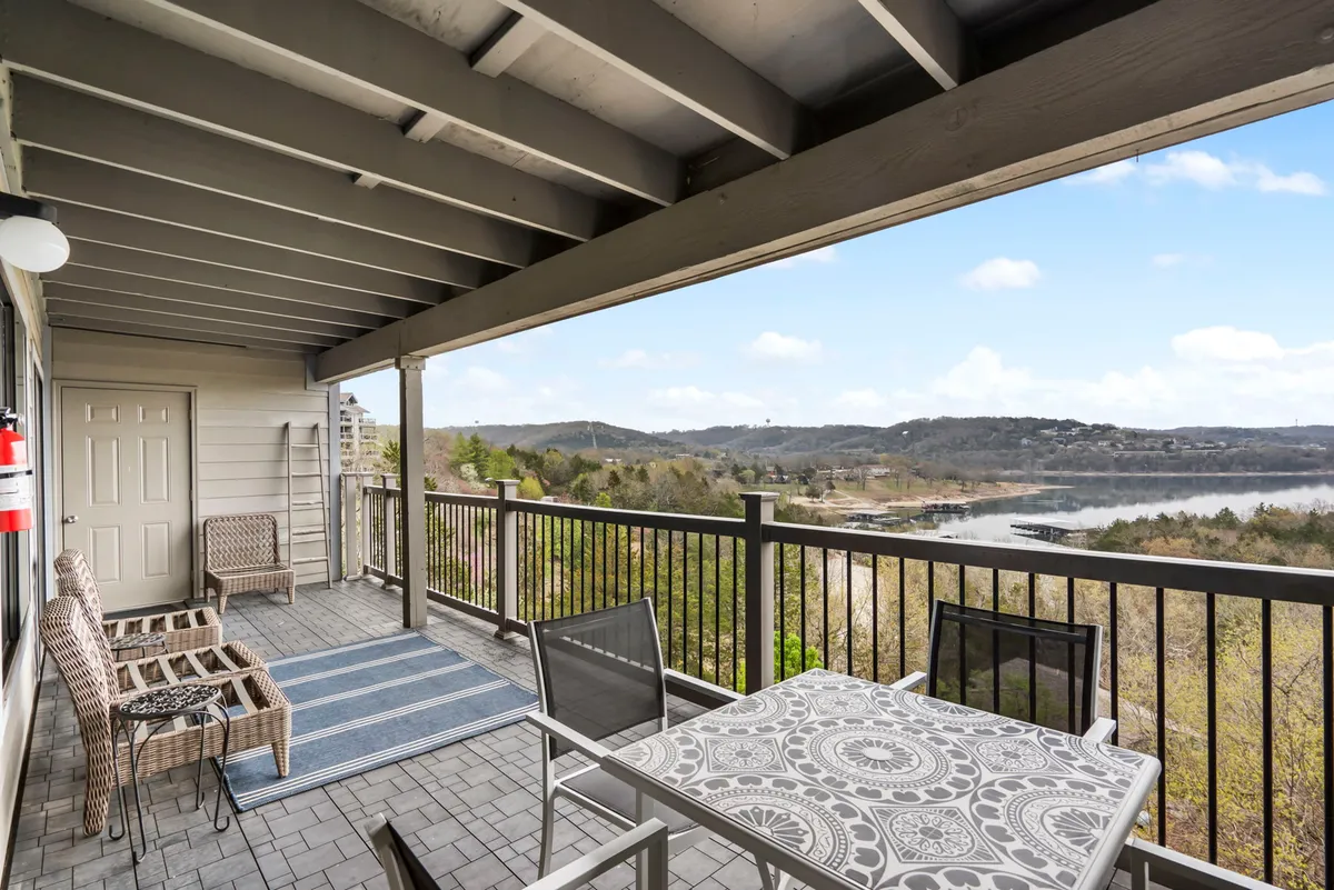 A peaceful outdoor deck overlooking Table Rock Lake, furnished with comfortable seating and protective railings. The view captures the serene expanse of water and surrounding landscape, while the deck itself invites guests to enjoy morning coffee, sunset drinks, or relaxed conversation.
